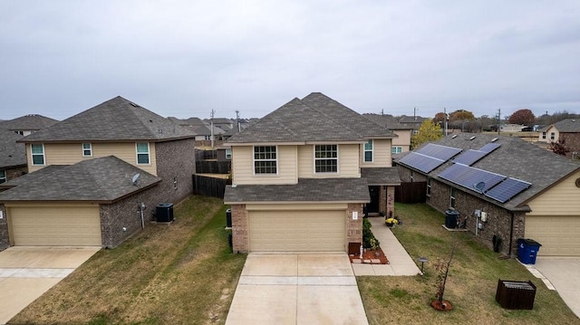 view of front property featuring central AC, a front yard, and a garage