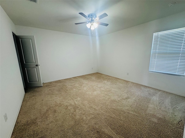 unfurnished room with ceiling fan and light carpet