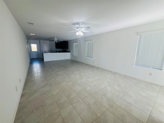 unfurnished living room with light tile patterned floors and ceiling fan