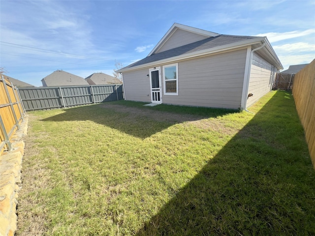 rear view of property featuring a lawn