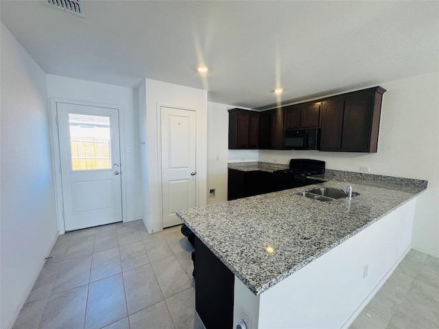 kitchen with sink, dark brown cabinets, light stone countertops, black appliances, and kitchen peninsula