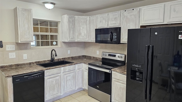 kitchen featuring light tile patterned floors, sink, white cabinetry, and black appliances