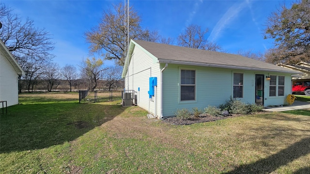 view of front of property featuring a front yard and central AC unit