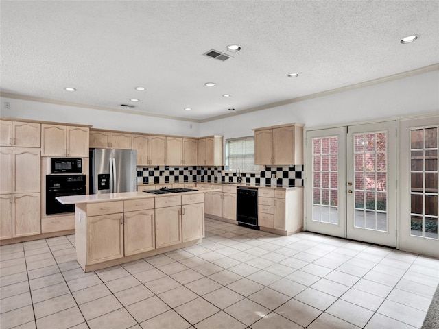 kitchen featuring light brown cabinetry, decorative backsplash, black appliances, and a kitchen island