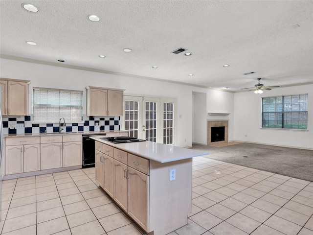 kitchen featuring dishwasher, light brown cabinets, decorative backsplash, and light tile patterned floors