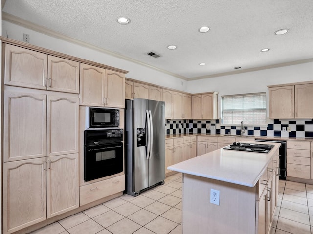 kitchen featuring light brown cabinets, backsplash, a center island, and black appliances