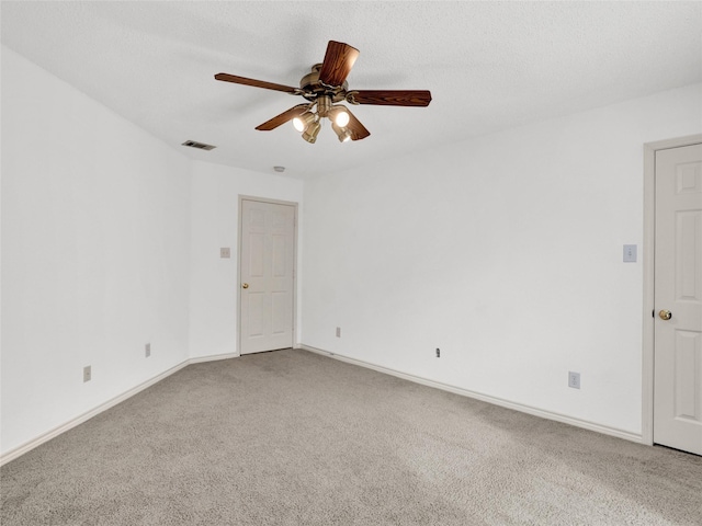 spare room featuring carpet flooring, ceiling fan, and a textured ceiling