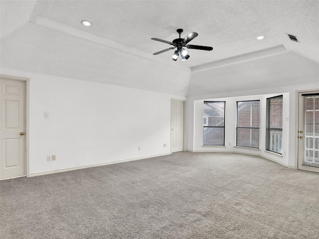 spare room with a tray ceiling, ceiling fan, carpet floors, and a textured ceiling