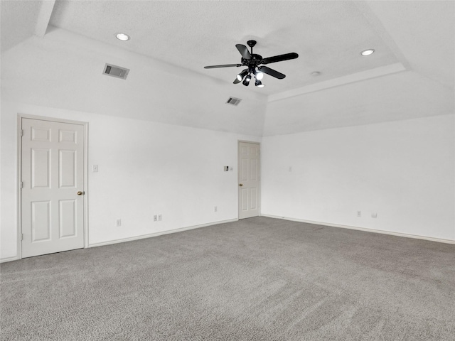 carpeted spare room featuring ceiling fan, a raised ceiling, and a textured ceiling