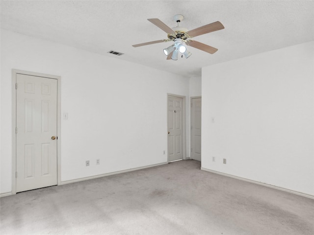 carpeted spare room with ceiling fan and a textured ceiling