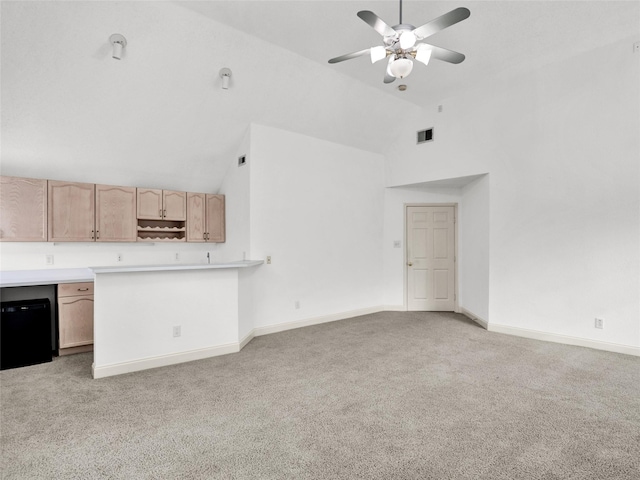 kitchen with light carpet, light brown cabinets, high vaulted ceiling, and ceiling fan