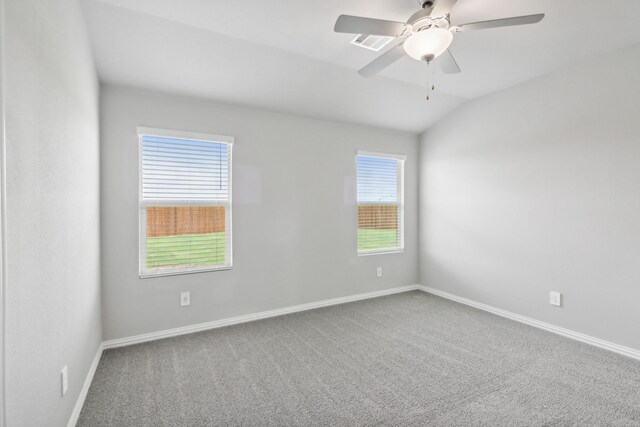 spare room featuring carpet, ceiling fan, and vaulted ceiling