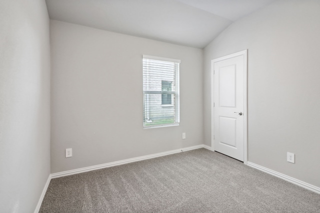 spare room with carpet flooring and vaulted ceiling