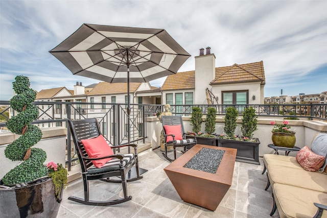 view of patio / terrace with an outdoor fire pit and a balcony