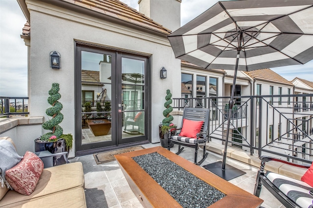 property entrance featuring a patio area, an outdoor living space, french doors, and stucco siding