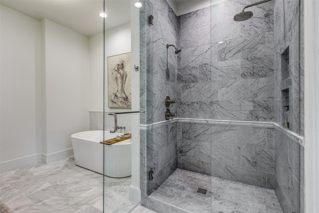 bathroom with a soaking tub, baseboards, marble finish floor, and tiled shower