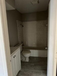 bathroom featuring vanity, toilet, and a tile shower