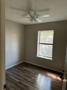 unfurnished room with ceiling fan, dark wood-type flooring, and a textured ceiling