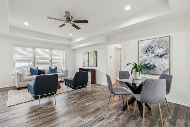 dining room featuring hardwood / wood-style flooring, ceiling fan, and a tray ceiling