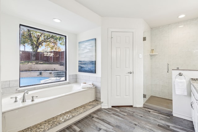 bathroom featuring hardwood / wood-style floors, vanity, and independent shower and bath