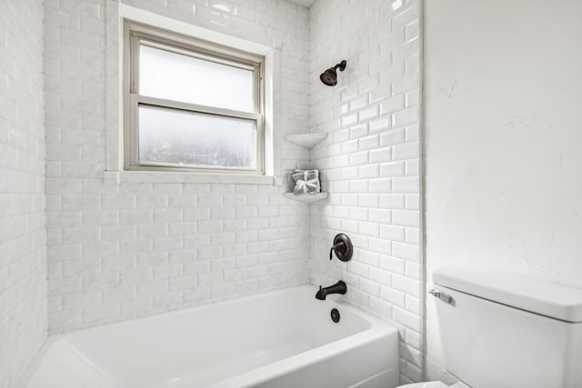 bathroom featuring toilet and tiled shower / bath