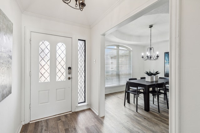 entrance foyer with hardwood / wood-style floors, a chandelier, and ornamental molding