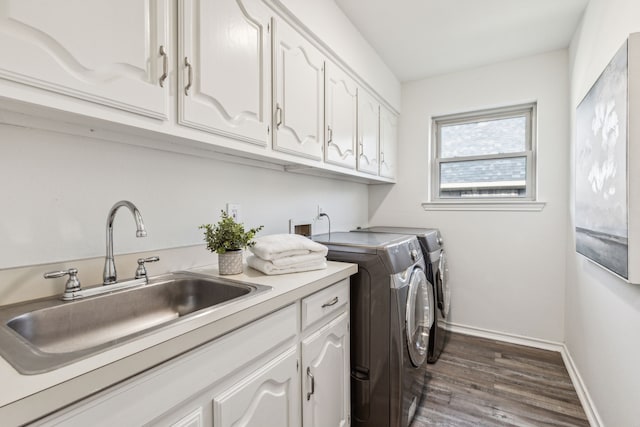 laundry room featuring cabinets, washer and dryer, dark hardwood / wood-style flooring, and sink