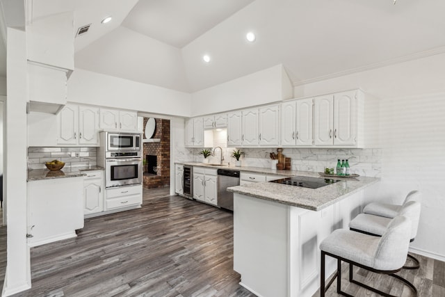 kitchen featuring white cabinets, appliances with stainless steel finishes, decorative backsplash, and dark wood-type flooring