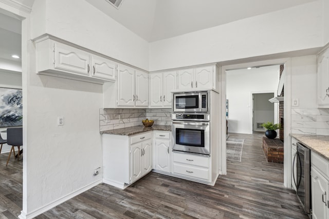 kitchen featuring decorative backsplash, white cabinetry, dark hardwood / wood-style floors, and appliances with stainless steel finishes