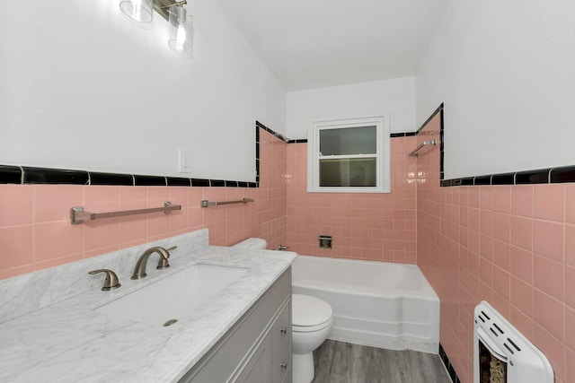 full bathroom with hardwood / wood-style flooring, vanity, tile walls, and toilet