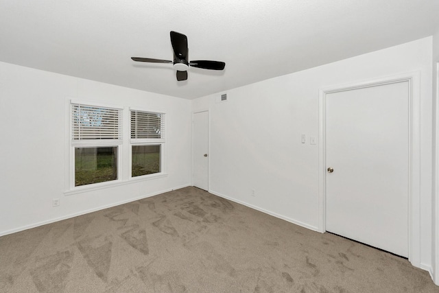 carpeted empty room featuring ceiling fan