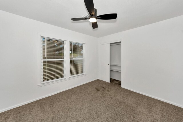 unfurnished bedroom with carpet floors, ceiling fan, and a closet