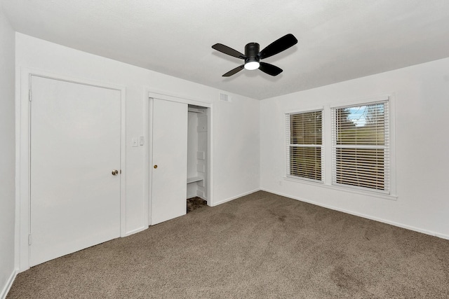 unfurnished bedroom with dark carpet and ceiling fan