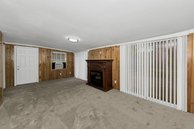 unfurnished living room with carpet floors and wood walls