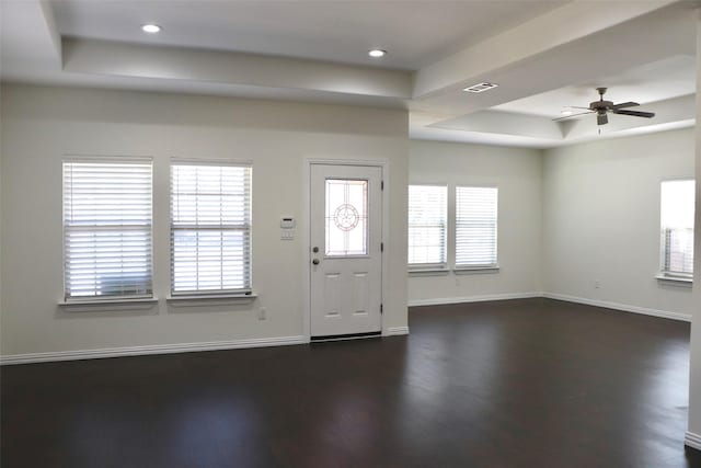 foyer entrance with a tray ceiling, dark wood-type flooring, and ceiling fan