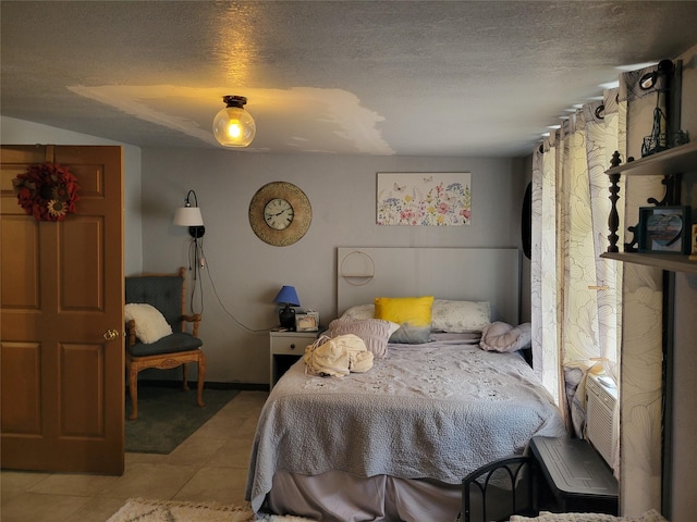 bedroom with light tile patterned flooring and a textured ceiling