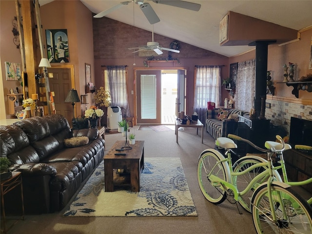 carpeted living room with vaulted ceiling, ceiling fan, and a wood stove