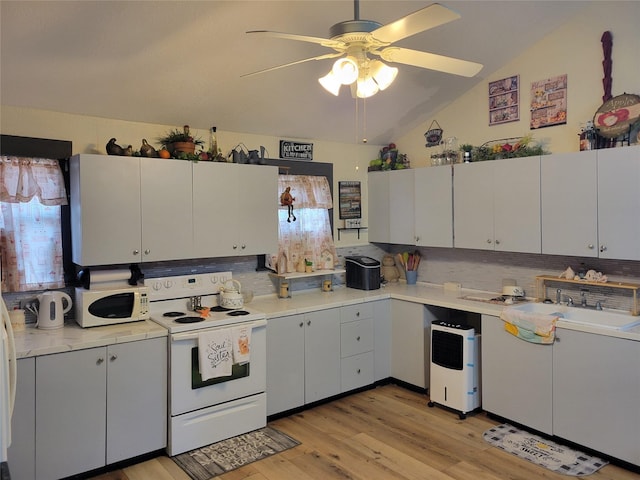 kitchen featuring white cabinetry, white appliances, sink, and vaulted ceiling