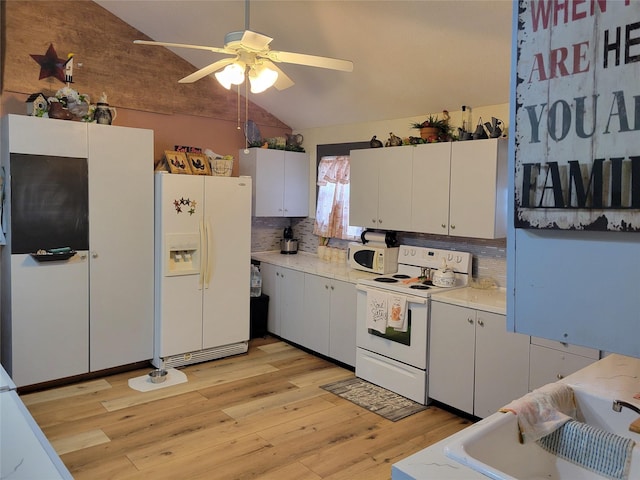 kitchen with vaulted ceiling, light wood-type flooring, white cabinets, white appliances, and backsplash