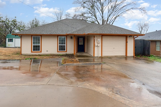 single story home with a garage, driveway, and roof with shingles