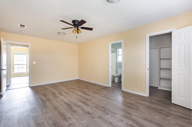 unfurnished bedroom featuring multiple windows, visible vents, and wood finished floors