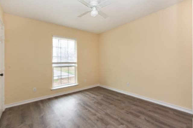 empty room with ceiling fan, baseboards, and dark wood finished floors