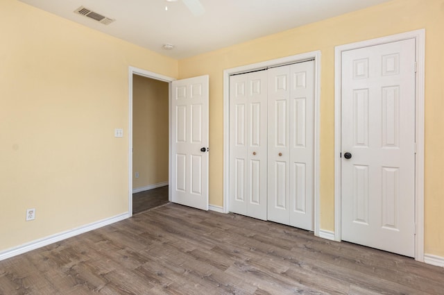 unfurnished bedroom with light wood-type flooring, baseboards, visible vents, and a closet