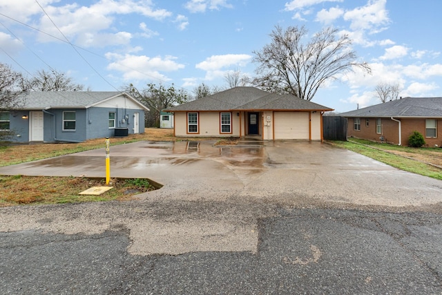 view of front of home featuring a garage, driveway, and roof with shingles