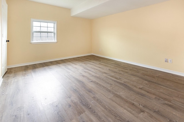 unfurnished room with baseboards and wood finished floors