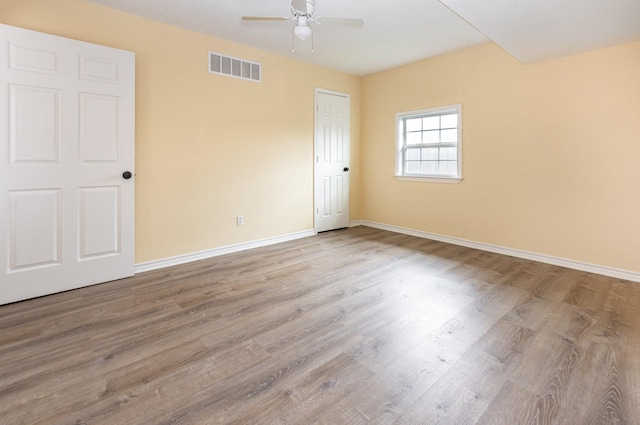 unfurnished room featuring light wood-style flooring, visible vents, ceiling fan, and baseboards