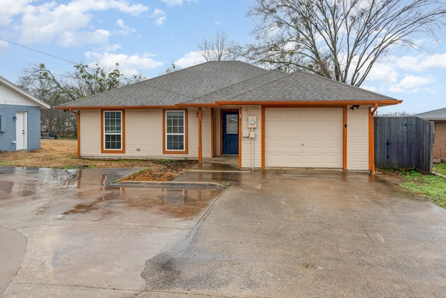 ranch-style home featuring a garage, driveway, a shingled roof, and fence