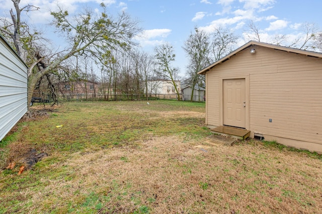 view of yard featuring an outdoor structure and fence