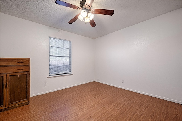 unfurnished room featuring ceiling fan, wood-type flooring, and a textured ceiling