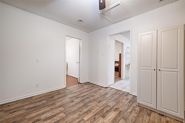 unfurnished room with hardwood / wood-style flooring and a textured ceiling